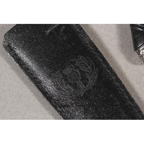 10 - Two sgian dubhs, a silver-plated and leather hip flask and a Scottish silver-plated belt plate.