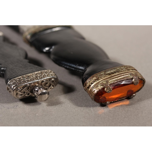 10 - Two sgian dubhs, a silver-plated and leather hip flask and a Scottish silver-plated belt plate.