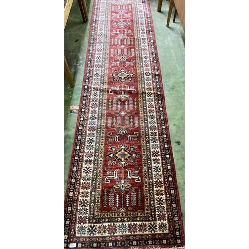 514 - Eastern red ground hall runner with multi border, 310cm x 75cm.