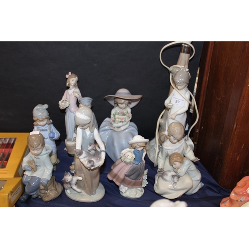 97 - Lladro, and other, figure groups to include cats, flowers, etc., and a table lamp.