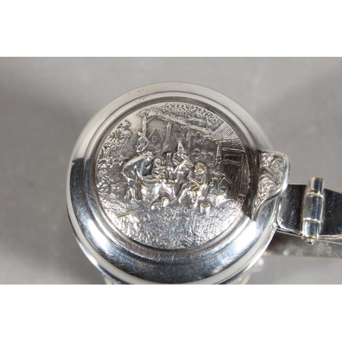 172 - Danish white metal lidded stein decorated in repousse with musicians, 14cm high.