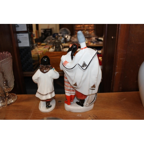175 - USSR porcelain model of a girl holding a flower and book, 20cm high, and a similar figure group.