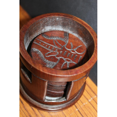 184 - Carved hardwood set of six coasters held in hut shaped box and a set of green glass brandy glasses w... 