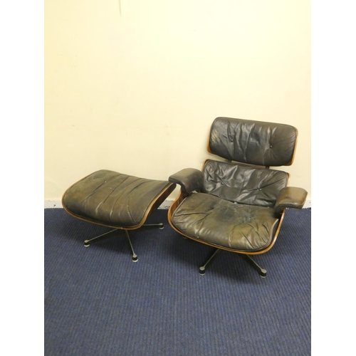 409 - Charles and Ray Eames chair and a footstool upholstered in black leather.
