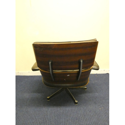 409 - Charles and Ray Eames chair and a footstool upholstered in black leather.