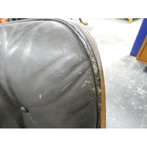409 - Charles and Ray Eames chair and a footstool upholstered in black leather.