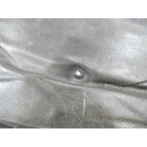 409 - Charles and Ray Eames chair and a footstool upholstered in black leather.
