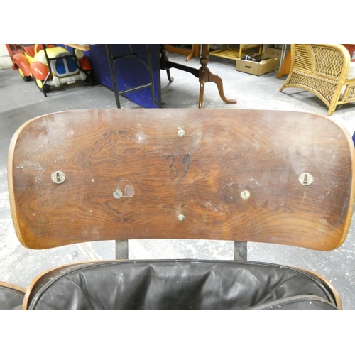 409 - Charles and Ray Eames chair and a footstool upholstered in black leather.