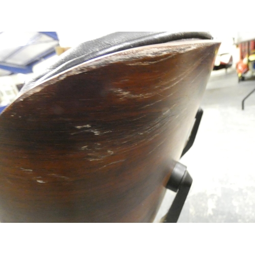 409 - Charles and Ray Eames chair and a footstool upholstered in black leather.
