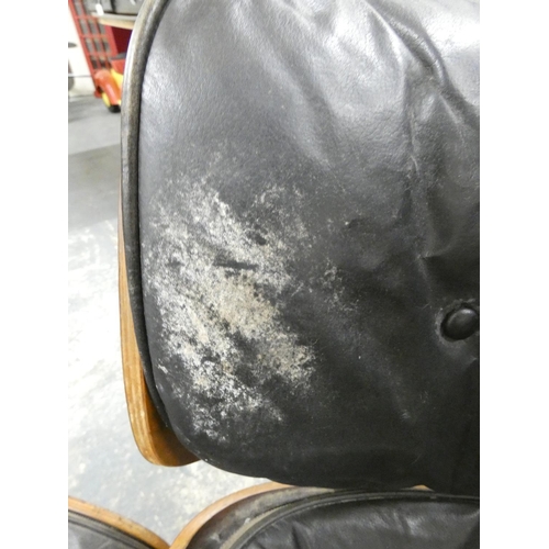 409 - Charles and Ray Eames chair and a footstool upholstered in black leather.