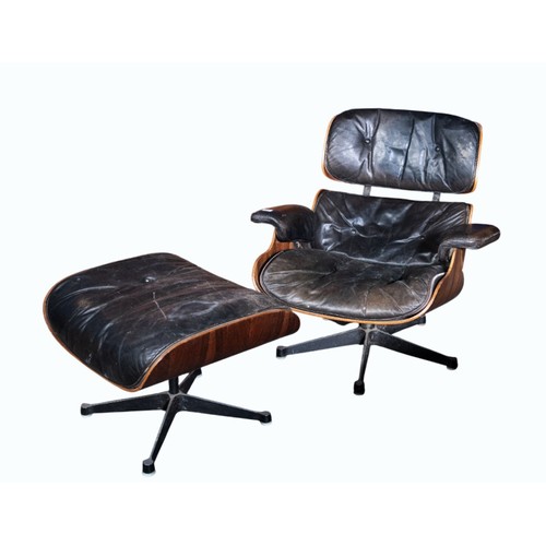 409 - Charles and Ray Eames chair and a footstool upholstered in black leather.