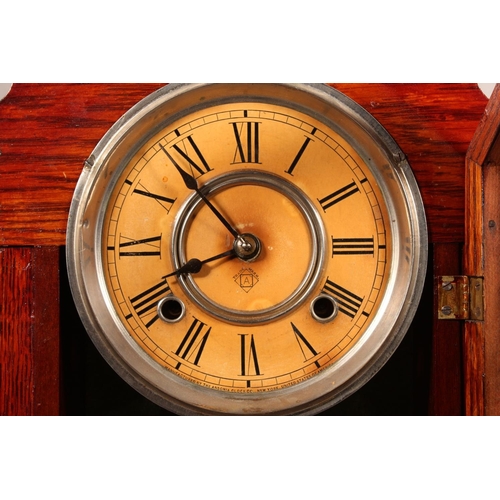 102 - Ansonia clock with Roman numeral chapter ring and carved wood case.