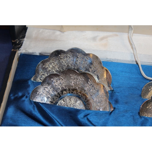 31 - Cased set of six coffee cans and teaspoons, with matching saucers in white metal casings....