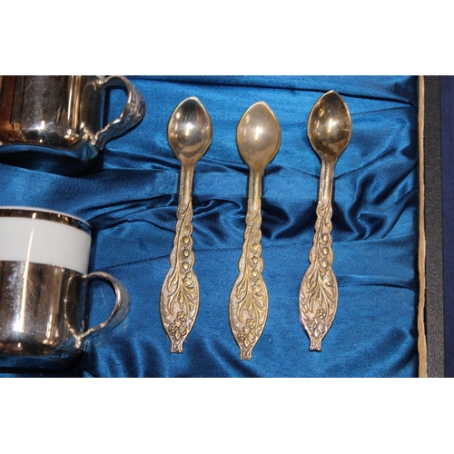 31 - Cased set of six coffee cans and teaspoons, with matching saucers in white metal casings....