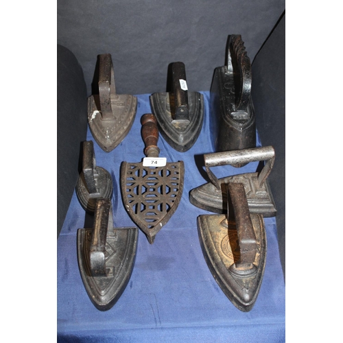 74 - Seven flat irons and a flat iron stand to include Swain, and others.
