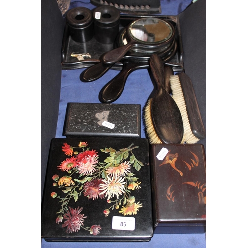 86 - Ebonised vanity sets, a floral decorated lacquered box and cover, another, etc.