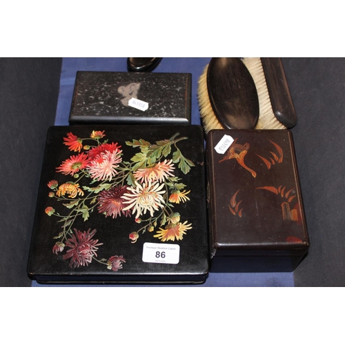 86 - Ebonised vanity sets, a floral decorated lacquered box and cover, another, etc.