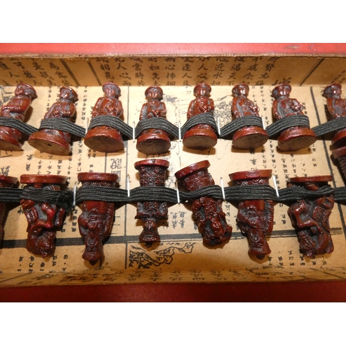 76 - Modern boxed Chinese export chess pieces in red and white resin, depicting various immortals and oth... 