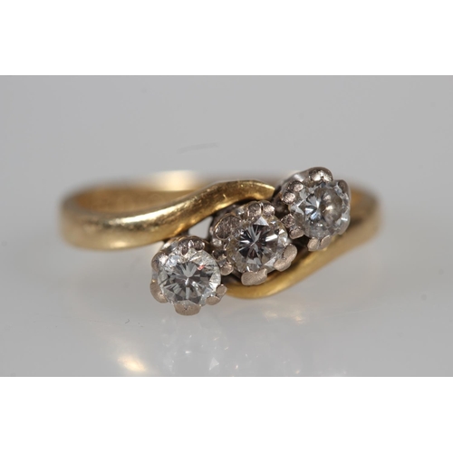 176 - 18ct yellow gold diamond three stone crossover ring, the diamonds and claw setting, size K, 3.4g.