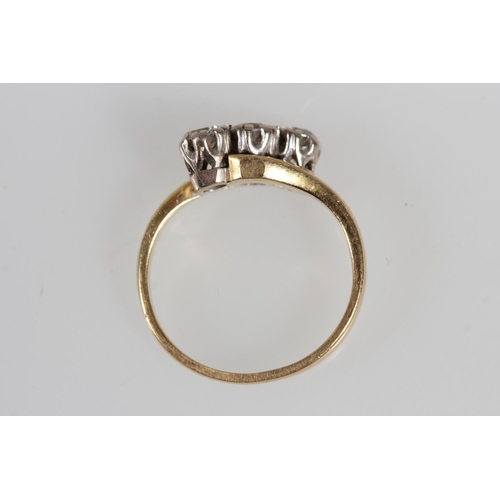 176 - 18ct yellow gold diamond three stone crossover ring, the diamonds and claw setting, size K, 3.4g.
