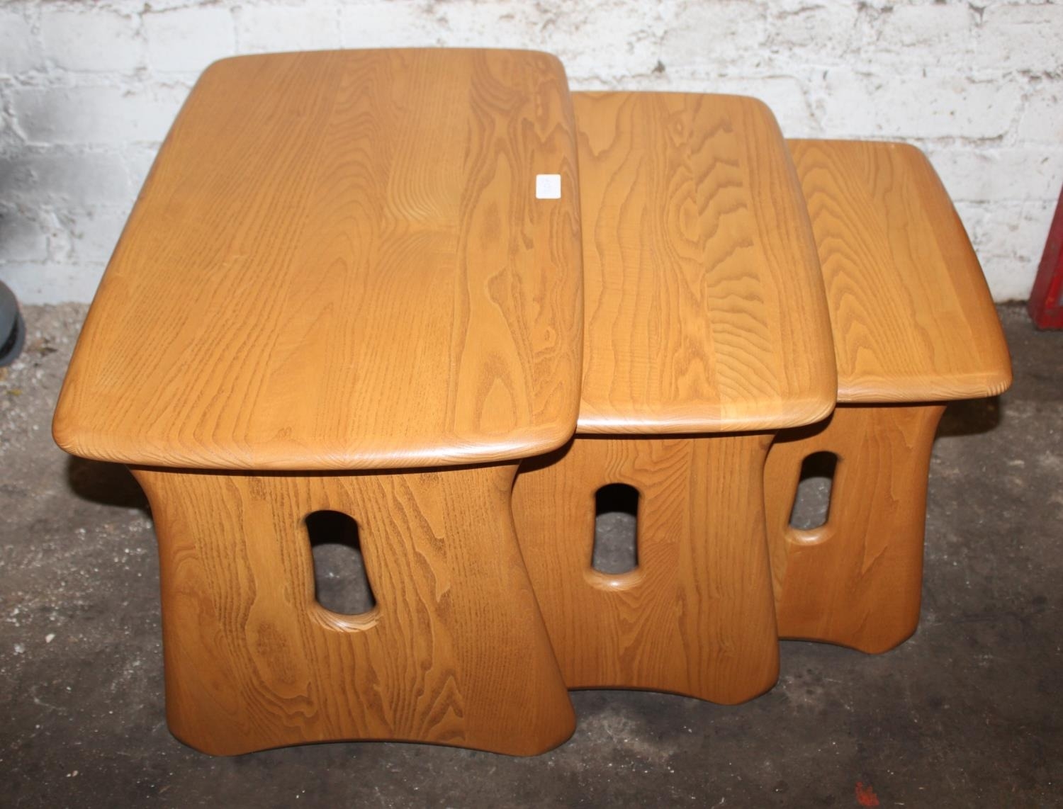 Modern Ercol nest of three blonde tone ash tea tables, 63cm long. (3)