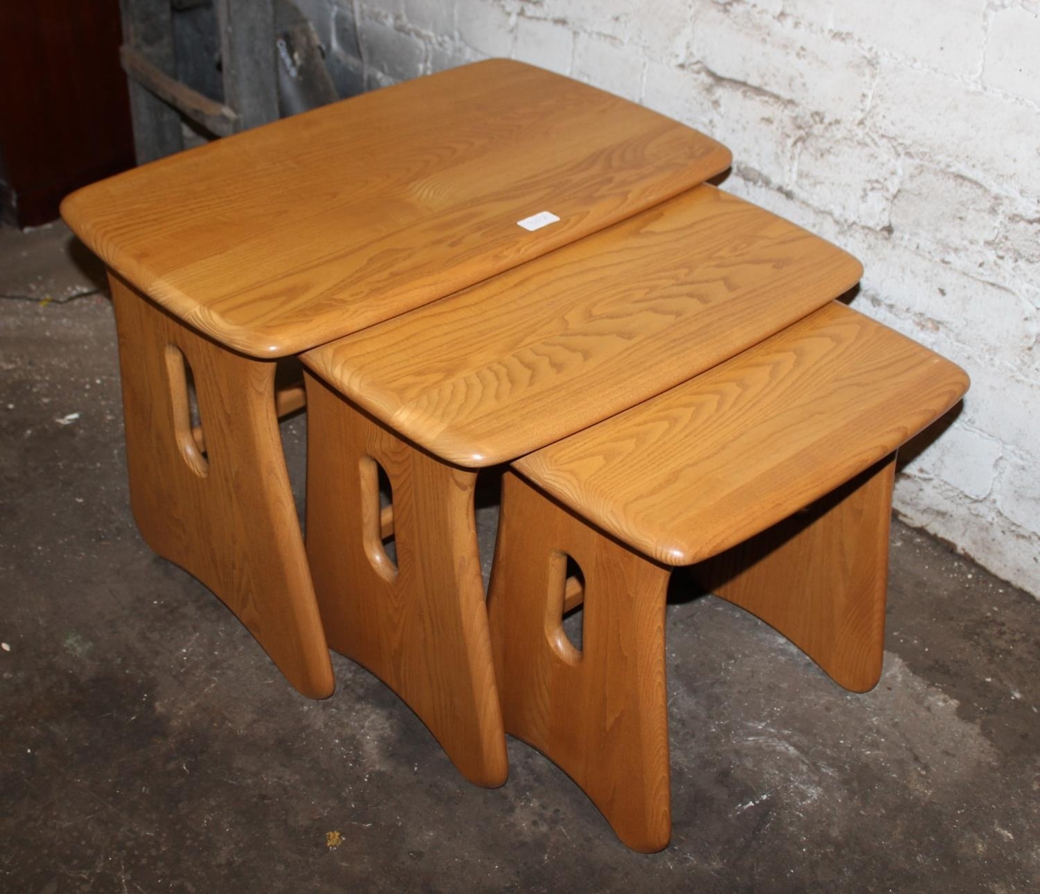 Modern Ercol nest of three blonde tone ash tea tables, 63cm long. (3)