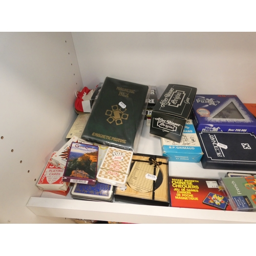 110 - Three shelves of sundries to include boxed model vehicles, games, reels of thread and ornaments, sof... 