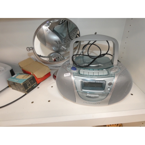 113 - Three shelves of sundries to include Panasonic 2-alarm/clock and cd player, fan heater, ornaments to... 