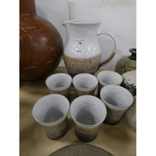 74 - Collection of studio pottery to include a water set, Tremar style bean pot with cover, coin bank in ... 