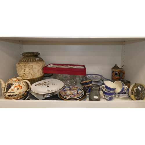 98 - Two shelves of sundries to include prints, postcards, ceramics, Westclox clock, crystal etc.