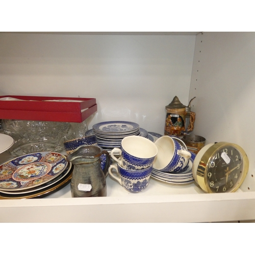 98 - Two shelves of sundries to include prints, postcards, ceramics, Westclox clock, crystal etc.