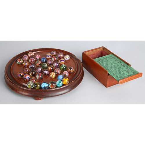 157 - Collection of antique marbles in a box, 'The Improved Game', and a related mahogany solitaire board.