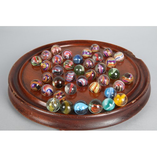 157 - Collection of antique marbles in a box, 'The Improved Game', and a related mahogany solitaire board.