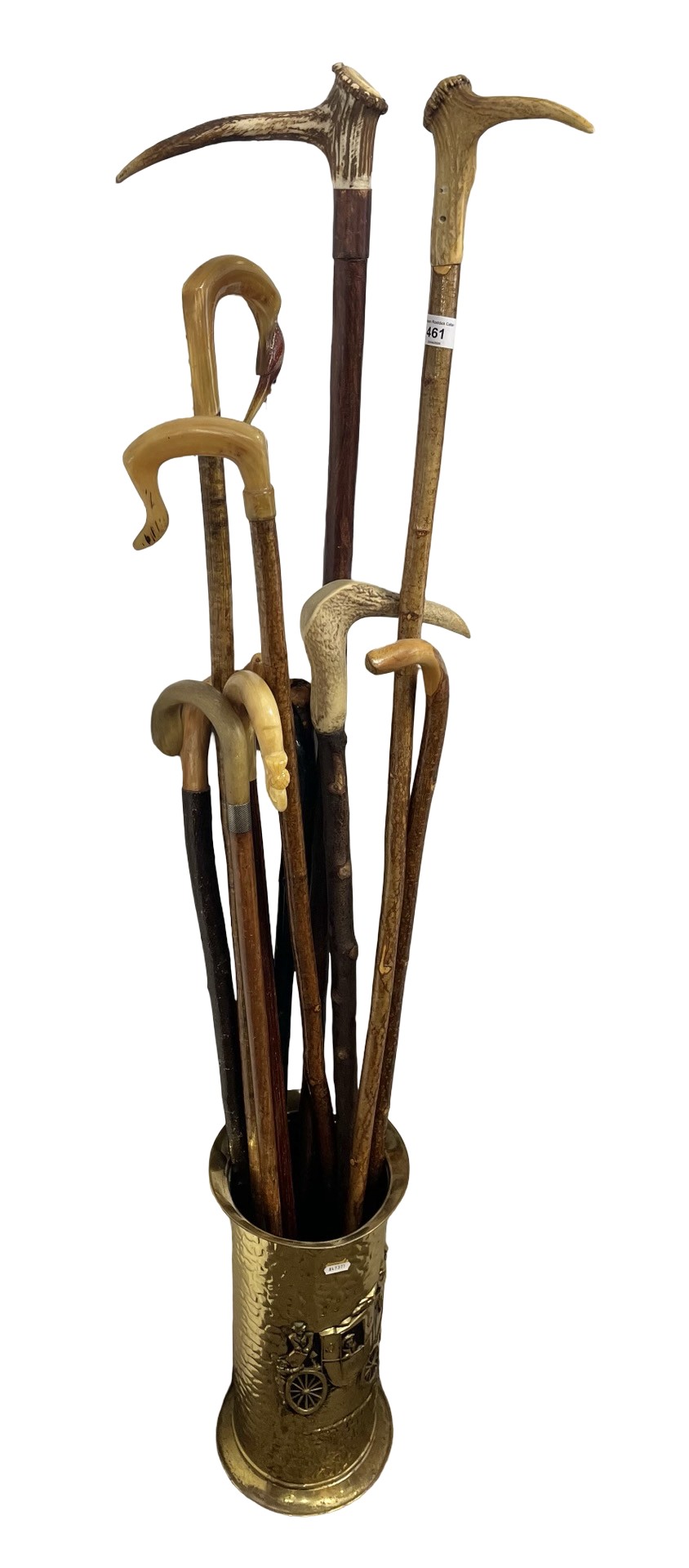 Brass embossed stick stand with various walking sticks.