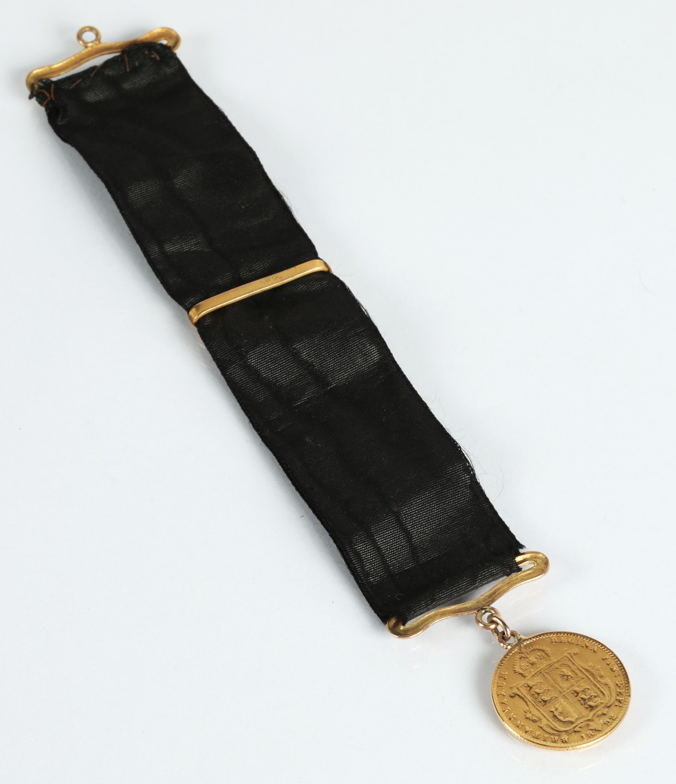 Victorian gold half sovereign 1892 mounted to a ribbon.
