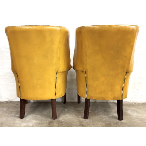 324 - Pair of chesterfield wingback chairs upholstered in mustard yellow leather. 113cm high, 80cm wide.