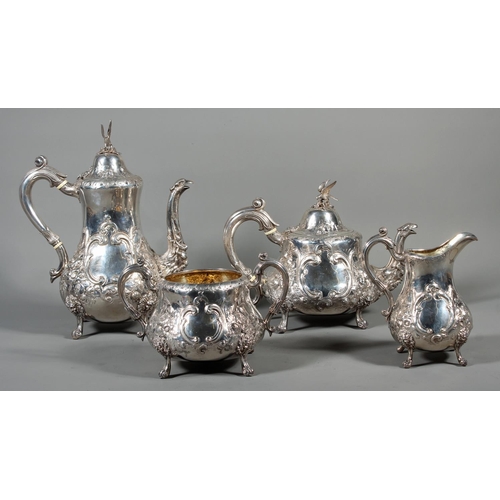 82 - Victorian silver four piece tea service having all over repousse floral, Rococo scroll and green man... 