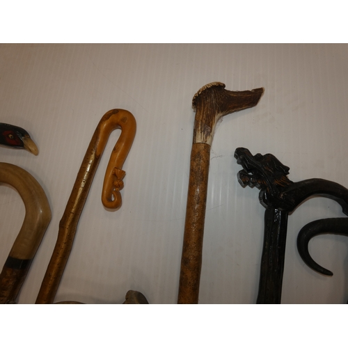 90 - Group of walking sticks to include an example with an antler grip and another with a pheasant head.