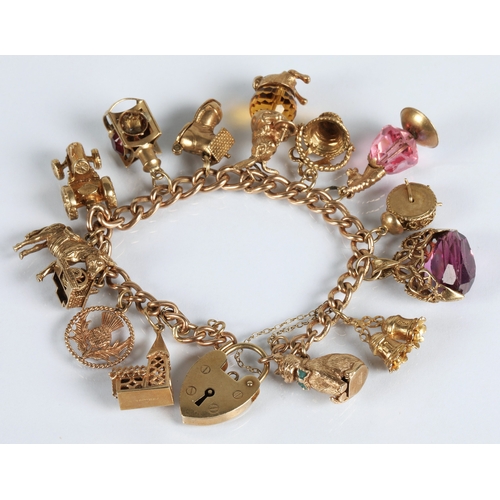 83 - 9ct gold charm bracelet with fourteen assorted gold charms to include cat, bells, clock, tractor, et... 