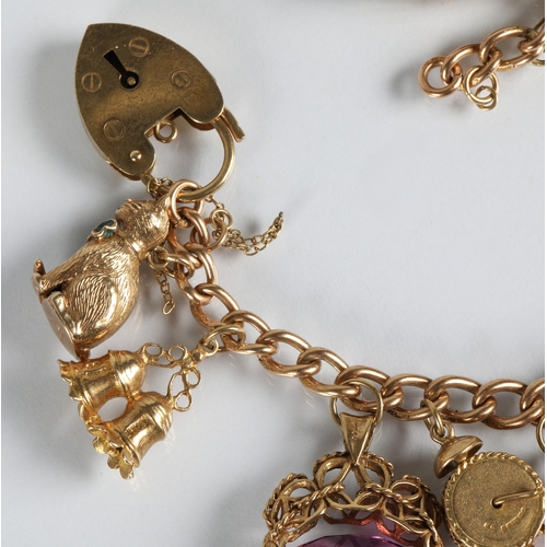 83 - 9ct gold charm bracelet with fourteen assorted gold charms to include cat, bells, clock, tractor, et... 