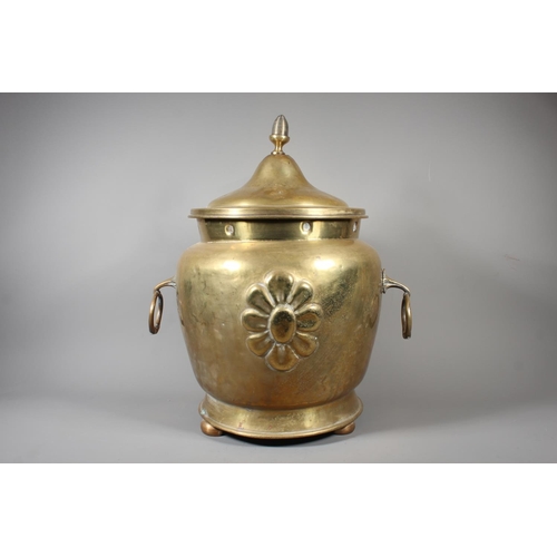 7 - Large brass jardini&egrave;re with twin handles and embossed floral front and topped finial, 50cm ta... 