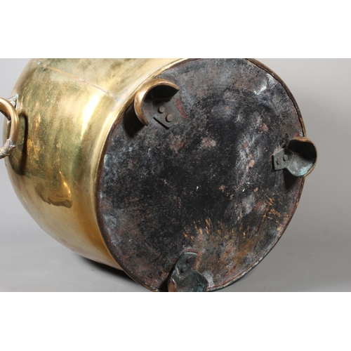7 - Large brass jardini&egrave;re with twin handles and embossed floral front and topped finial, 50cm ta... 
