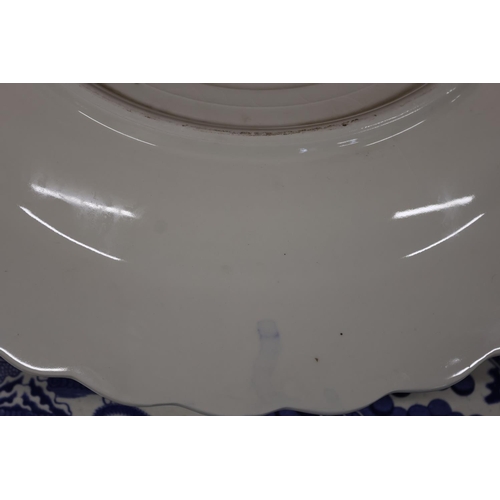20 - Blue and white charger depicting country scene and a Willow pattern ashet.
