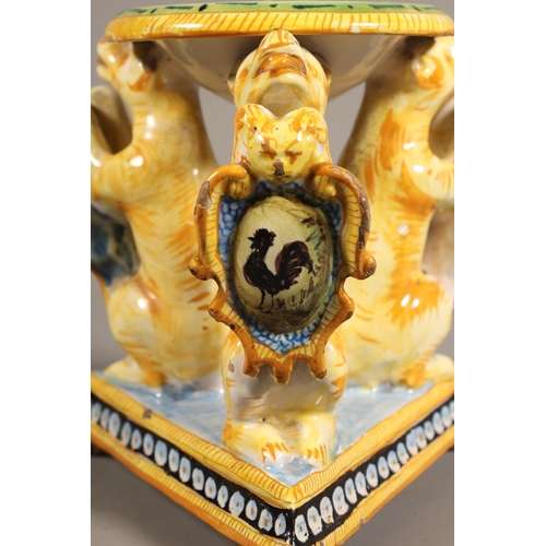 33 - Majolica style centrepiece, central dish painted with portrait, over triple lion stand.