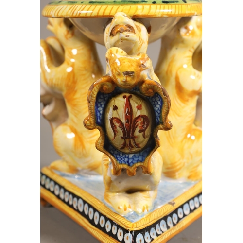 33 - Majolica style centrepiece, central dish painted with portrait, over triple lion stand.