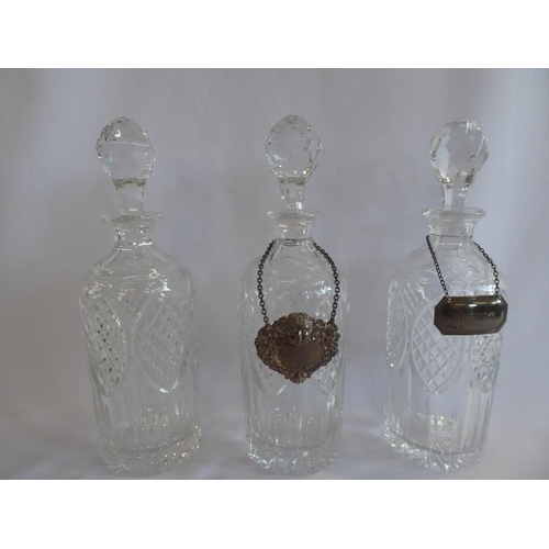 80 - Trio of cut glass decanters with 2 silver labels on plated stand