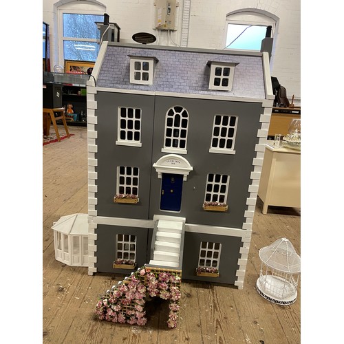 242 - Four storey wooden dolls house with, Steps, lighting, conservatory, band stand, and other accessorie... 