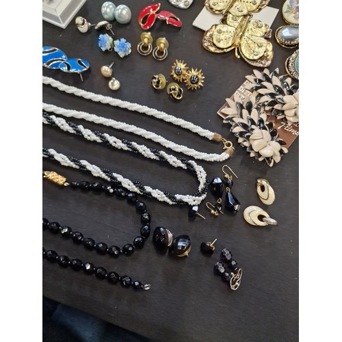 1 - A collection of vintage jewellery including paired earinhs, necklaces, lapel clips, necklaces and br... 