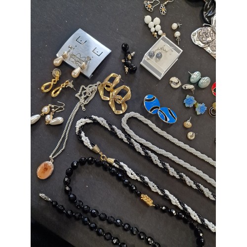 1 - A collection of vintage jewellery including paired earinhs, necklaces, lapel clips, necklaces and br... 