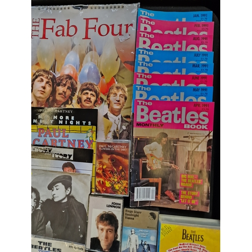 172 - A large collection of the Beatles memorabilia including 13 45's, the fab four calander, the deathles... 